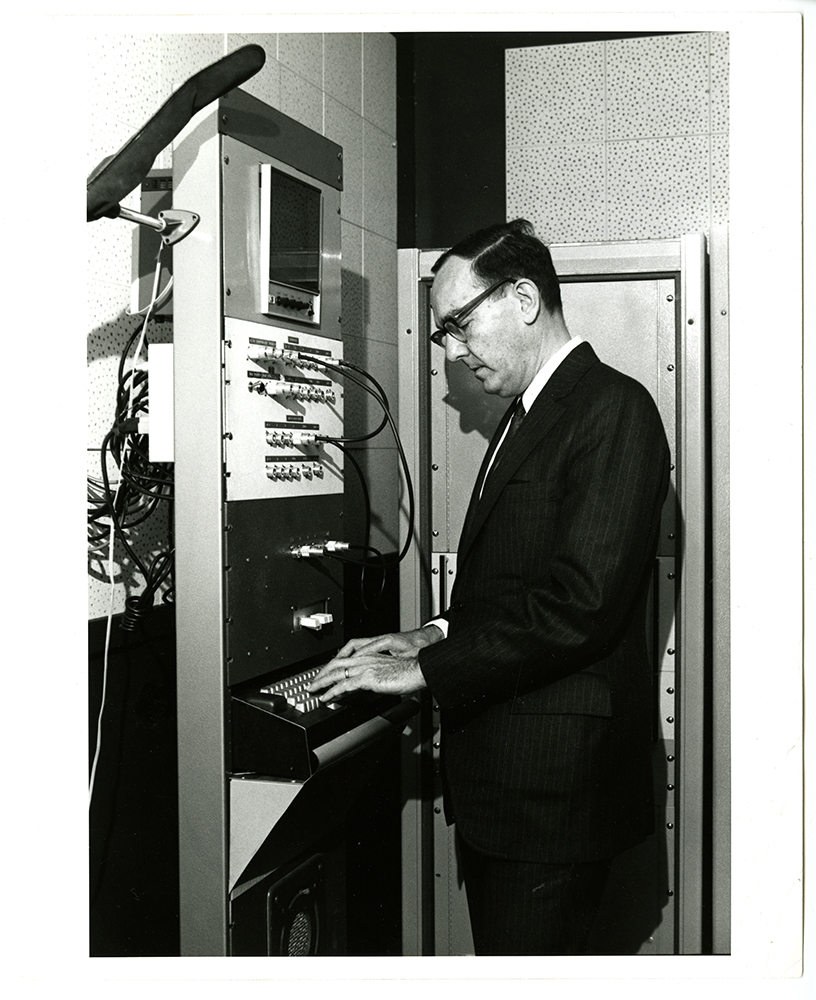 Herb Simon in front of an early computer