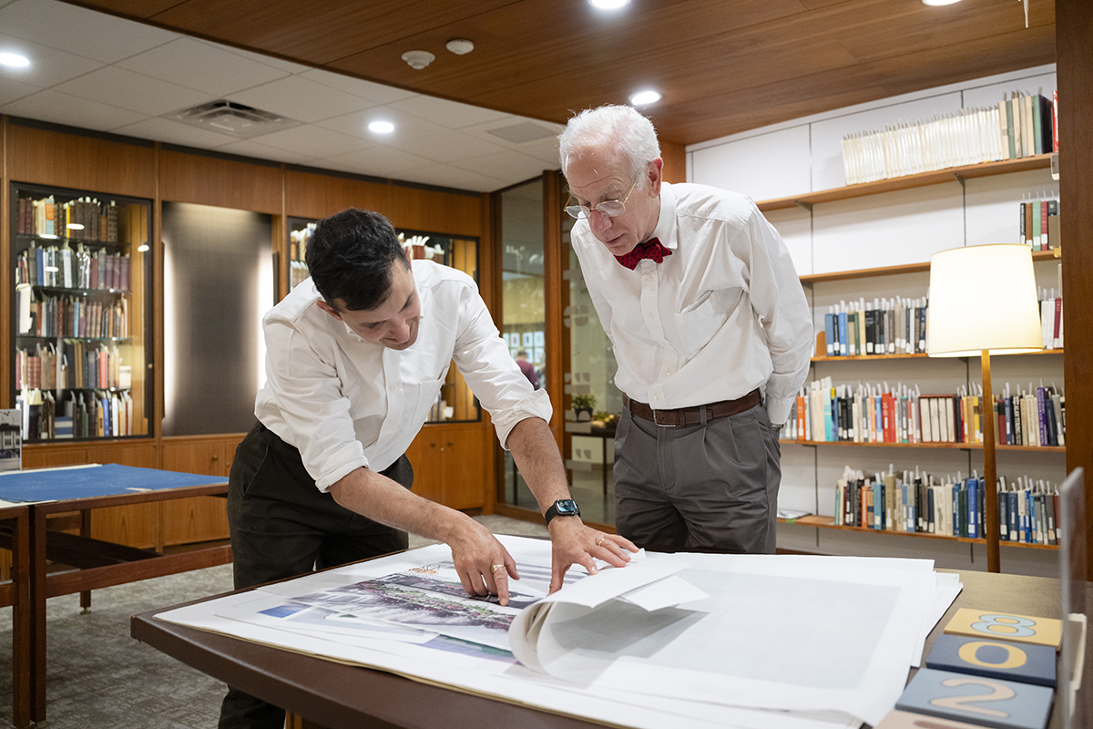 Curator of Special Collections Sam Lemley shares drawings and sketches of the Kraus Campo (located above the Posner Center on campus) with Henry Posner III, chairman of the Railroad Development Corporation.