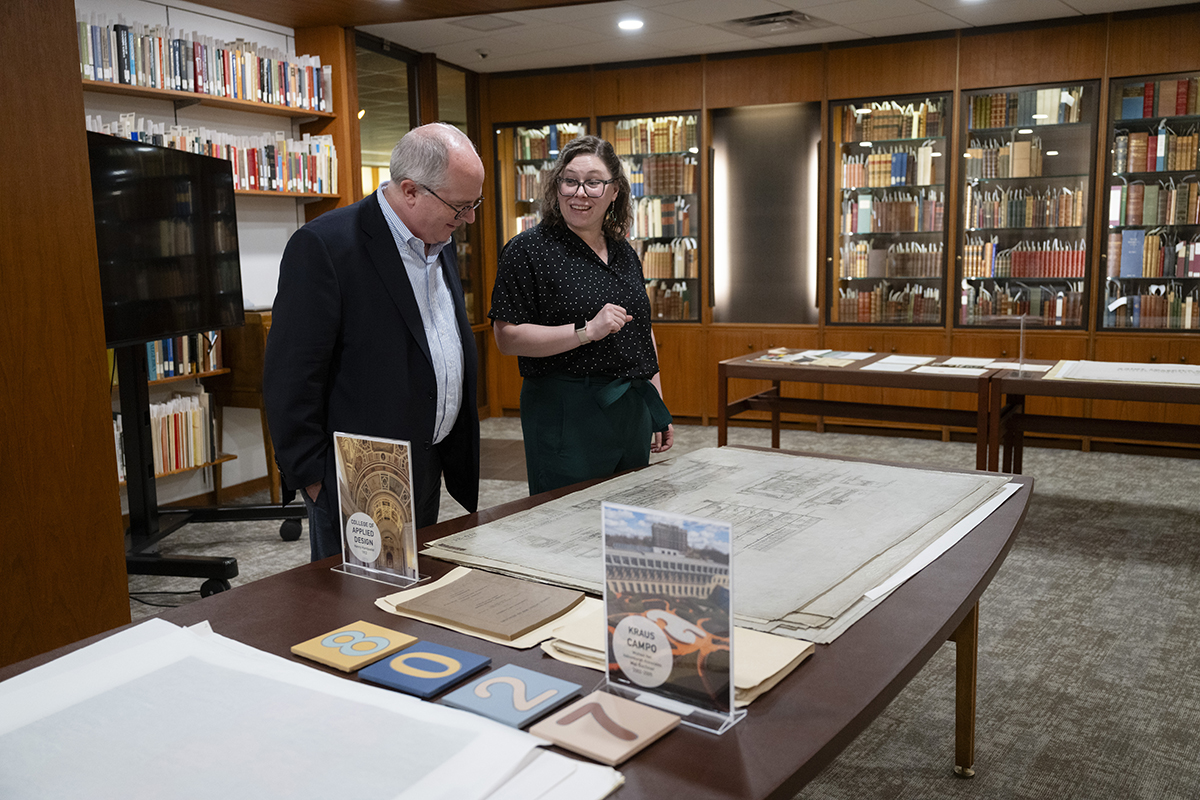 Associate Dean for Distinctive Collections Julia Corrin and Chief Investment Officer Charles Kennedy look at the original drawings of the College of Applied Design (now the College of Fine Arts) designed by Henry Hornsbostel.