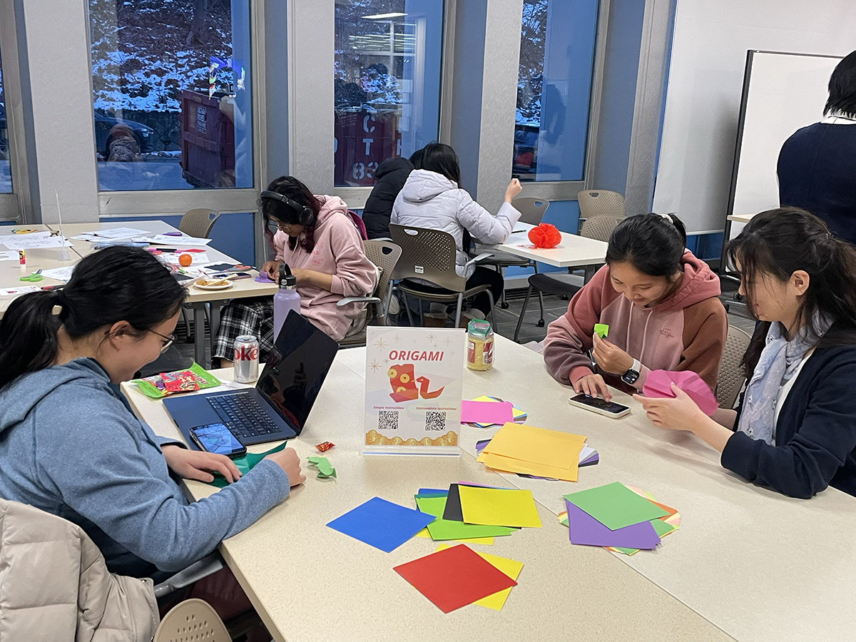 Students follow instructions to create origami snakes.