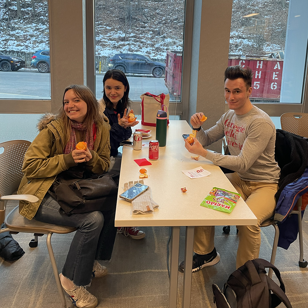 A group of students enjoys oranges, a traditional Lunar New Year treat believed to bring good fortune.