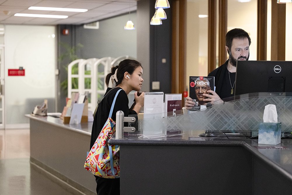 Patrick Hannay helps a student at the front desk