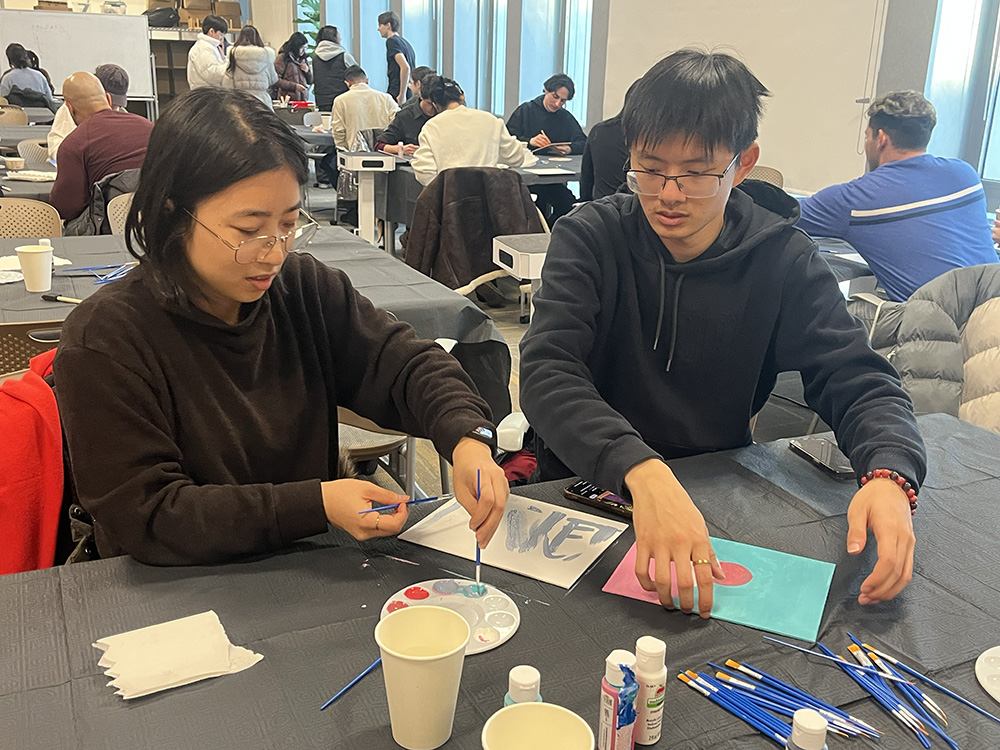 Two participants sketch out the first steps of their paintings.