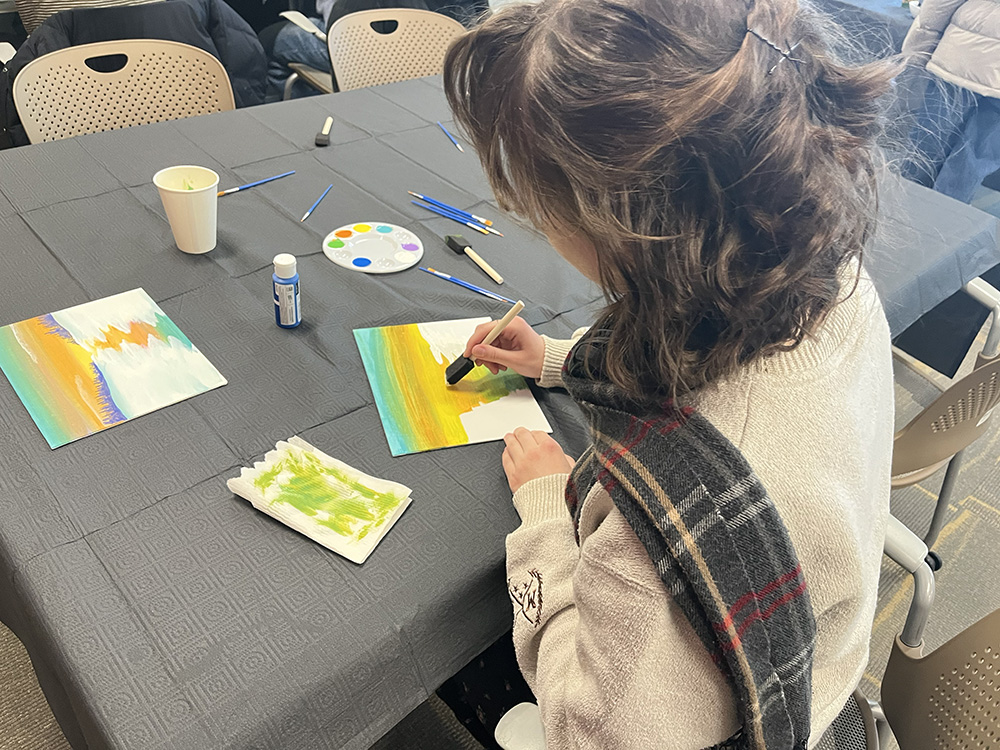 An attendee blends multiple colors to create a sunset.