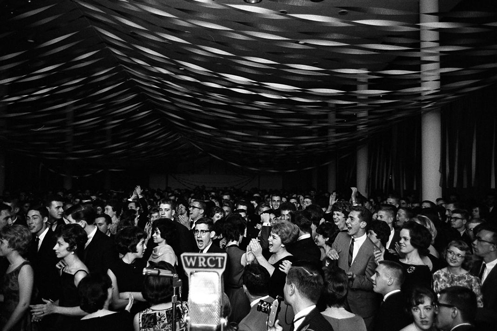 Behind a WRCT microphone, a crowd of college students enjoy themselves at the Fall Festival Dance held in Skibo Hall.