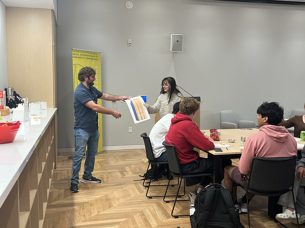 Checchio awards a winner with a poster of Herman Melville’s “The Whale” (an early printing of “Moby Dick”).