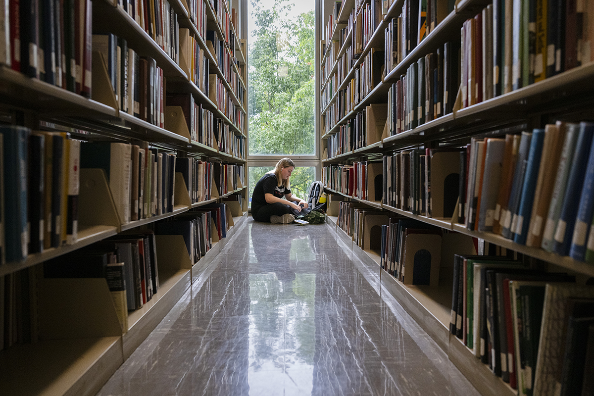 Student sits on the floor studying in Hunt Library. Photo by Rebecca Devereaux.