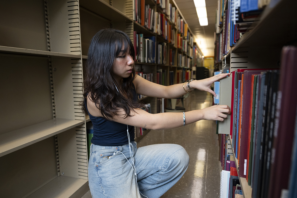 Student looking for books in Hunt Library. Photo by Rebecca Devereaux.